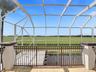 SCREENED BALCONY OVERVIEWING POOL AND OPEN FIELD TO ENJOY BEAUTIFUL ROMANTIC SUNSETS.