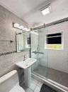 Pedestal sink, wall-mounted vanity lighting, frameless glass shower enclosure, subway tile shower surround, and hexagonal tile shower floor