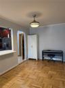 Parquet wood flooring, a ceiling-mounted light fixture, and an arched entryway