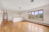 Expansive interior space featuring wood flooring, a multi-pane window with wood-finish trim,