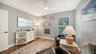 Bright guest bedroom or flexible space with hardwood flooring.