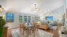 Open concept dining and living areas with hardwood floors and vaulted ceilings.