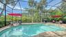 Heated free-form saltwater pool surrounded by tropical landscaping and privacy screening.