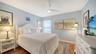 Comfortable guest bedroom with hardwood flooring and natural light.
