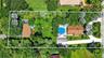 Large property with gorgeous grounds and mature trees, view of guest house on left and main house on right, separated by fence