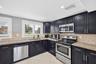 Large bright kitchen w/ windows everywhere, plantation shutters, wood cabinets, stainless appliances and granite counters