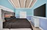 Oversized primary bedroom w/ beamed ceiling, Plantation Shutters and large walk in closet, en suite bathroom, on main level. Virtually Staged.