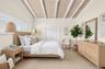 Oversized primary bedroom w/ beamed ceiling, Plantation Shutters and large walk in closet, en suite bathroom, on main level. Virtually Staged.