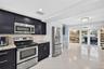 Large bright kitchen w/ windows everywhere, plantation shutters, wood cabinets, stainless appliances and granite counters