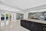 Large bright kitchen w/ windows everywhere, plantation shutters, wood cabinets, stainless appliances and granite counters