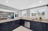 Large bright kitchen w/ windows everywhere, plantation shutters, wood cabinets, stainless appliances and granite counters