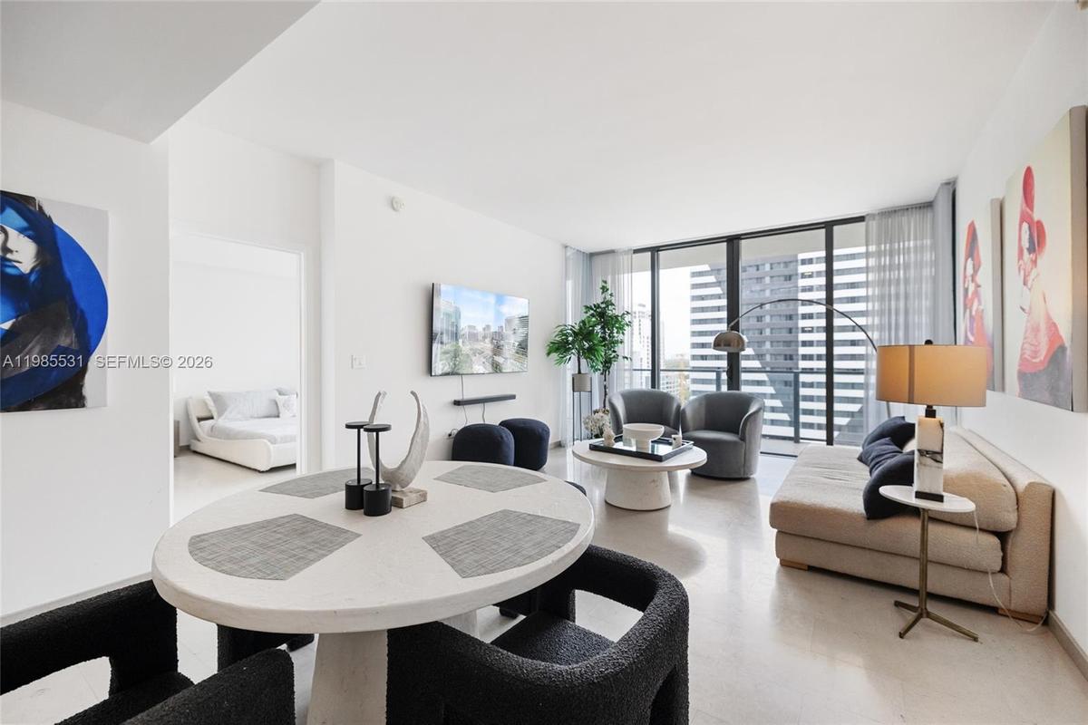 Neutral-toned tile flooring, floor-to-ceiling glass wall, and modern high-contrast aesthetic
