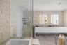Neutral interior featuring solid-core doors, light-toned tile flooring, and integrated wall-mounted television hardware