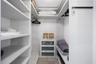 Floor-to-ceiling sliding glass door, spacious private balcony, and light-toned tile flooring throughout
