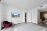 Custom walk-in closet featuring extensive built-in white shelving, integrated multi-level hanging rods, and a center built-in drawer unit with frosted