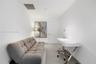 Stacked white laundry appliance set housed in a dedicated closet featuring a louvered door