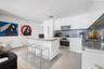 Kitchen featuring flat-panel white cabinetry, a center island with countertop seating, stainless steel appliances, recessed ceiling lighting, and tile