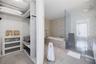 Modern wall-mounted vanity featuring a light-toned solid surface countertop, integrated sink, large-format frameless mirror, and polished chrome fauce