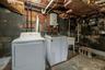Laundry area featuring electric panel, unfinished concrete floors, and washing machine and dryer