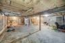 Unfinished basement featuring stairway and heating unit
