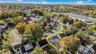 Aerial view of property and surrounding area with nearby suburban area