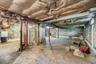 Unfinished below grade area featuring heating unit and gas water heater
