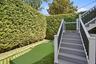 Turf lawn and putting green with stairs to primary bedroom private deck