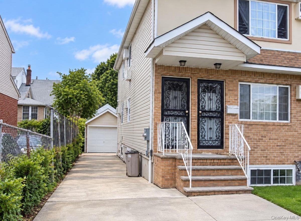 Brick and siding exterior with dual entry doors, decorative security screens, and a concrete driveway