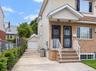 Brick and siding exterior with dual entry doors, decorative security screens, and a concrete driveway