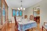 Hardwood flooring throughout, a multi-pane window with wood trim, and a chandelier lighting fixture