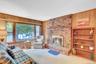 Brick fireplace with hearth,  and a large window over looking  the yard.