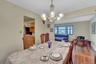 Wood-finish flooring, and a decorative chandelier illuminate the space