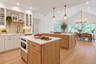Virtually staged with a chandelier and pendant lighting, this spacious eat-in kitchen features two generous countertops, perfect for cooking, entertai
