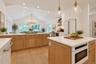 Another view of this spacious eat-kitchen, showcasing its generous layout, abundant counter space, and inviting dining area.