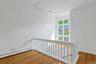 From the loft, we look over to the wall of windows that welcome in tons of natural light. There is a perfect seating area or spot for plants just in f