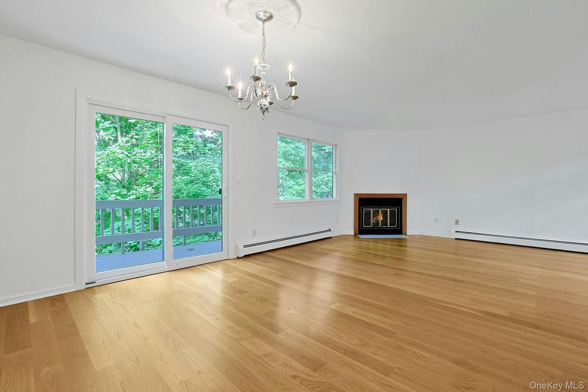 Centered under an elegant chandelier with a rosette, the dining room has sliding doors out to the rear deck.