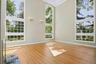 Impressive living room with high ceiling and massive windows that allow natural light and views of  property.