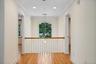 Balcony over looking the living room on one side and the foyer on the other.  Hardwood flooring, crown molding, recessed lighting, arched window, and 