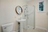 First floor hall bathroom with pedestal sink with polished chrome fixtures, frameless glass shower enclosure with subway tile surround, window with wh