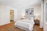 Bedroom #2 Virtual staging. With a bathroom with dual sinks, and door to the shower area.