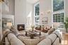 Virtual staging Living room with two story windows. An impressive room filled with natural light and views of the mature landscaping.