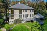 Stucco exterior with multi-pane windows, elevated deck, and a gazebo