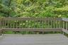 The rear deck is ensconced by beautiful trees. This is a great spot to sit with a cup of coffee in the morning or, perhaps, something a little stronge