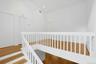 Up the beautiful staircase to the second level, we find the loft, which has a cathedral ceiling that soars to twelve feet overhead. Centrally located 