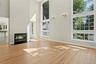 Living room with two story windows. An impressive room filled with natural light and views of the mature landscaping.