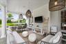 Covered veranda with sitting area and dining area.