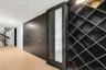 An elegant built-in wine wall featuring custom diamond-grid shelving and a modern glass-paneled accent door.