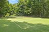 Private, beautifully maintained tennis court surrounded by lush, mature landscaping.