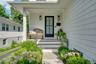 A charming covered front porch- the perfect spot for morning coffee, greeting neighbors, and taking in the beautifully landscaped surroundings.