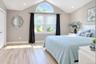 Vaulted ceiling with an arched window, finished flooring, and recessed lighting